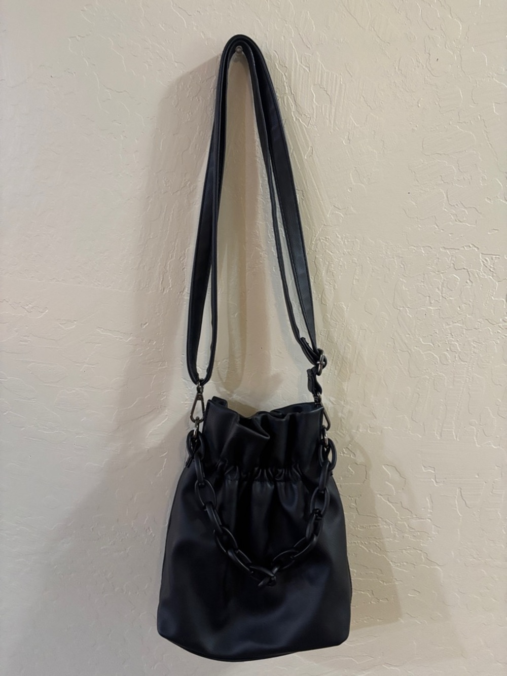 Sleek Black Drawstring Shoulder Bag with Chain Accent